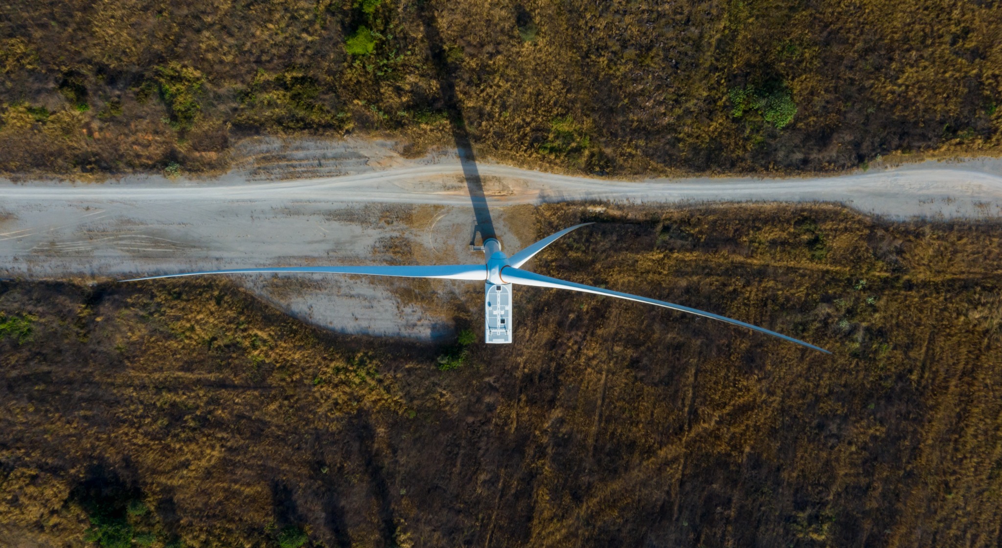 Aerial view of a wind turbine beside an access road
